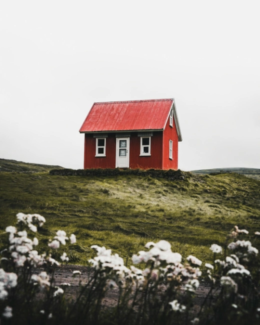 Red house on a green hill