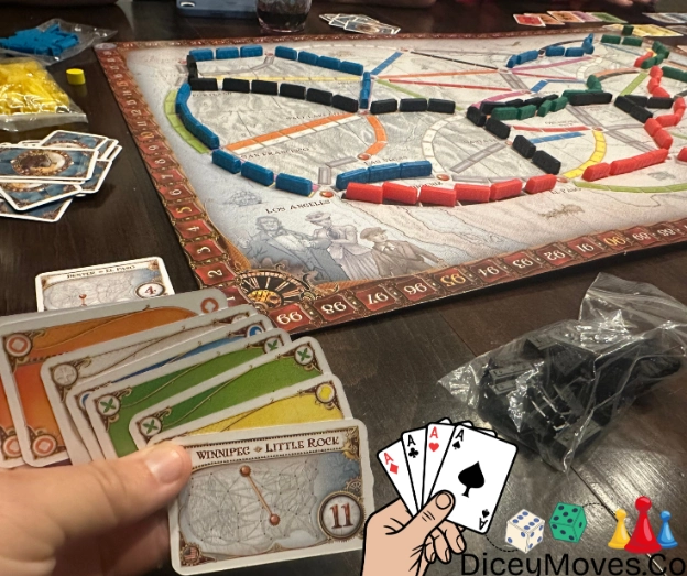 a game of ticket to ride in progress with trains on the board and cards in hand