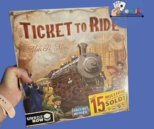 a ticket to ride game box being held in hand with a watch wrist band