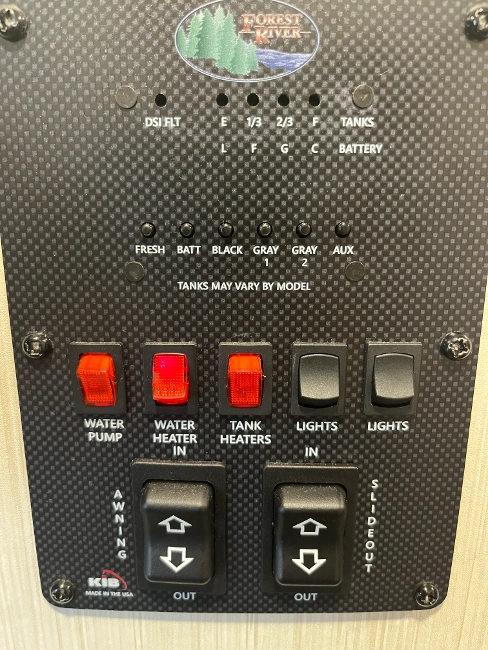  Forest River RV monitor panel showing tank levels and battery status in a standard RV setup.

