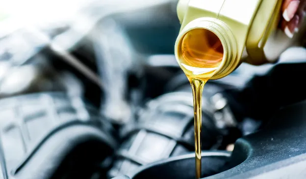  Fresh engine oil being poured into the engine—shows checking and topping off engine fluids during de-winterizing.