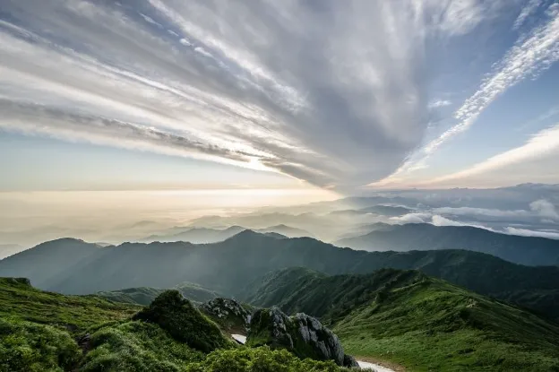 Scenic overlook of green countryside and mountain ranges showcasing the breathtaking views RVers often enjoy.

