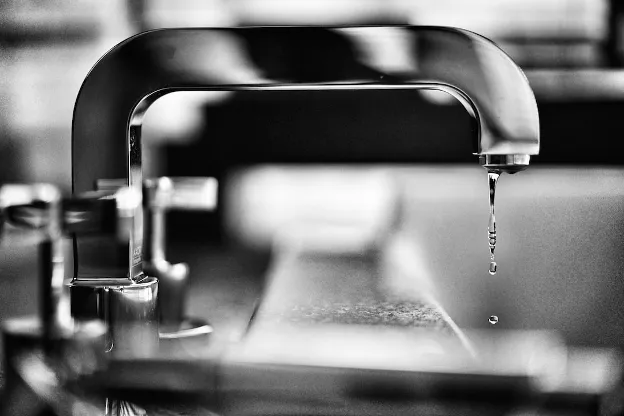  Water dripping from a chrome faucet—symbolizing the inspection of RV plumbing for leaks or damage after winter.