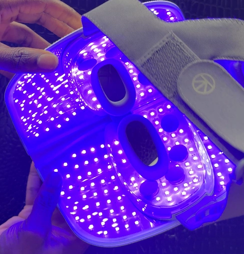TheraFace mask interior illuminated with bright blue LED lights for acne treatment.