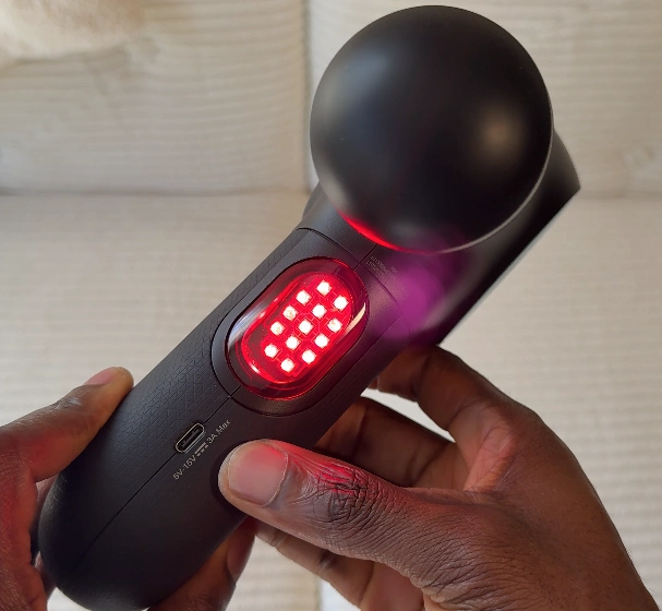 Theragun PRO Plus front view with active near-infrared LED therapy lights on.