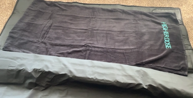 HigherDose infrared sauna blanket opened with black towel insert inside for hygiene and comfort.