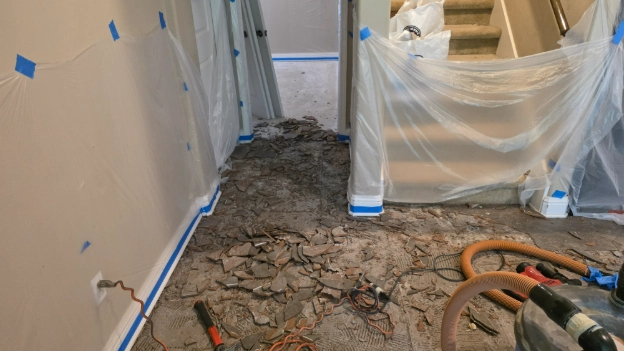 Tile removal underway in the dining area — dust containment and HEPA vacs running throughout.