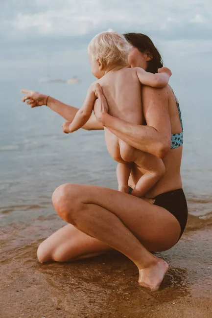 mother on the beach with her child shows him the sea