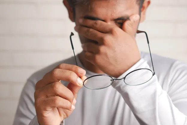 man rubbing eyes