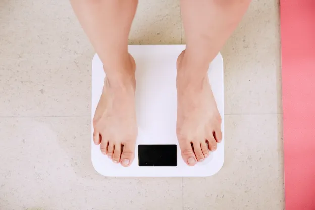 standing on a scale to measure weight