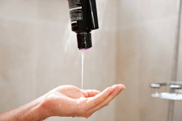 Squeezing shampoo on hand