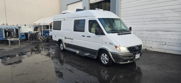 image of a freshly painted beautiful van outside of the repair shop.