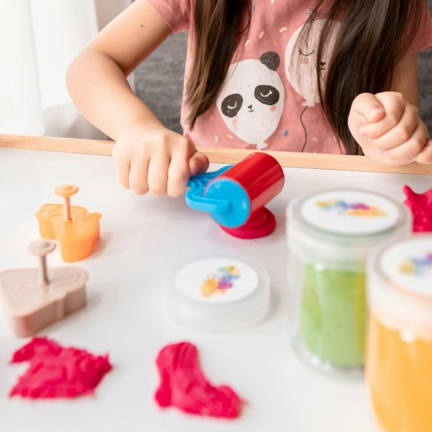 Child using a playdough roller to create shapes, a simple craft for kids at home that keeps them engaged and creative.