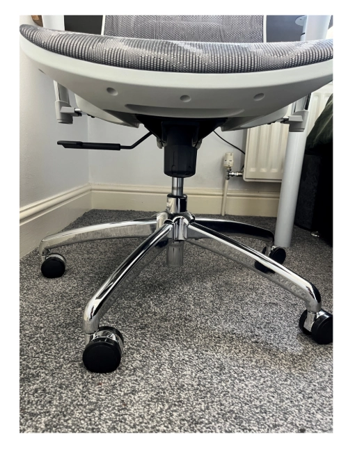 Close-up of the SIHOO Doro C300 chair base and wheels showing smooth movement on carpet and a sturdy metal frame.