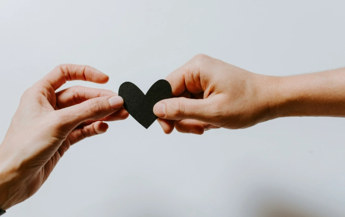 Two hands holding a heart shape symbolising connection and overcoming working from home isolation.