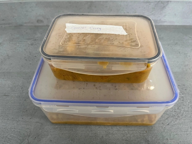 Freezer containers filled with slow cooker meal prep portions.