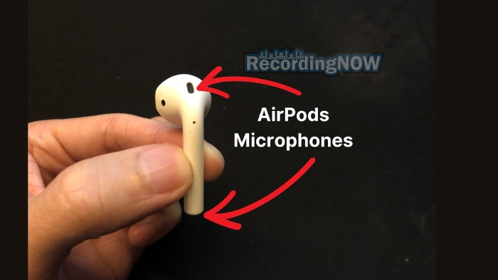 Holding AirPods 2 with red arrows pointing to microphones