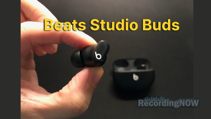 Holding Beats Studio Buds wireless earbud in hand