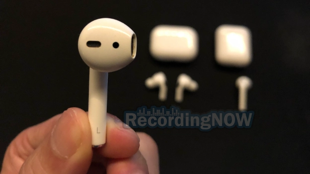 Holding AirPods 2nd gen earbud with AirPods Pro 2 in background