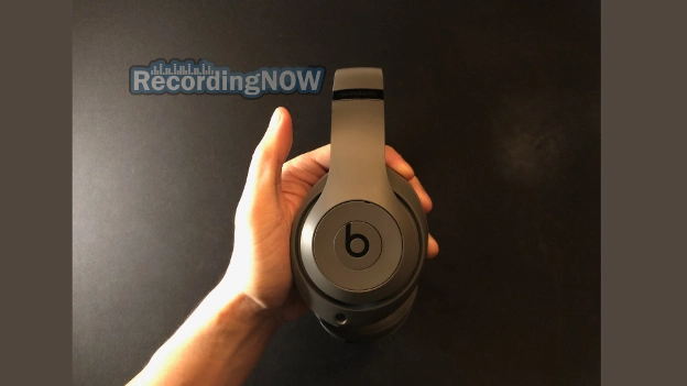 Holding Beats Studio 3 wireless headphones in hand