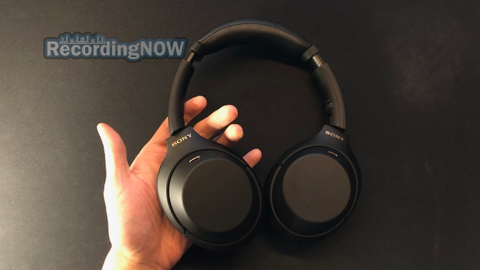 Holding Sony WH 1000XM4 headphones in hand