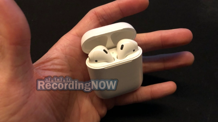 Apple AirPods 2 generation earbuds in charging case held in hand