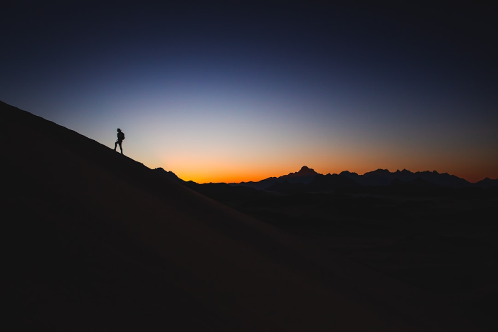 image of a person hiking up a mountain