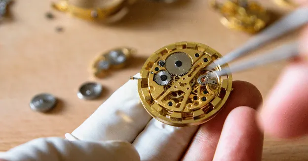 Picture of watch jewel being placed inside a watch component