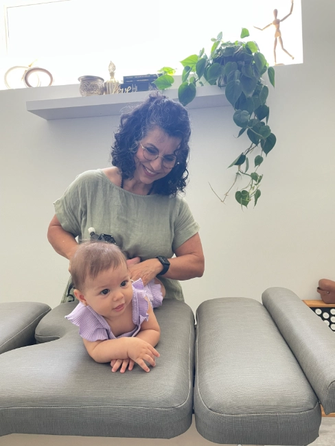 Baby getting a gentle chiropractic adjustment, a popular newborn bodywork method for healthy development.