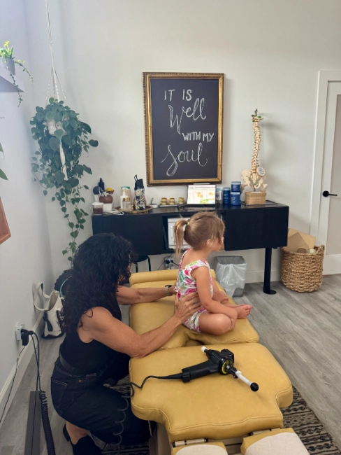 Toddler getting bodywork from a chiropractor to promote proper posture and roper development.