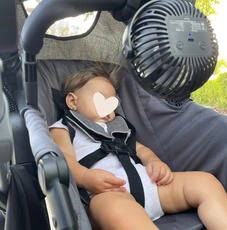 Portable fan attached to stroller for a hot summer stroll.